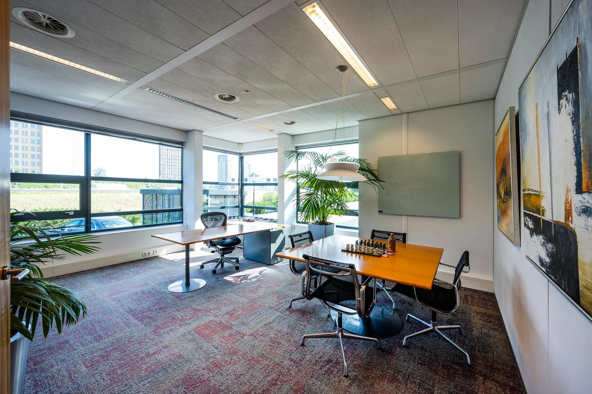 Modern kantoor aan de K.P. van der Mandelelaan met grote ramen, vergadertafel en schaakspel.